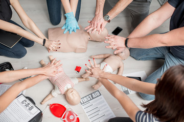 Class practising CPR compressions on training manikins
