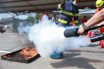 Trainee discharging a fire extinguisher at a live fire tray