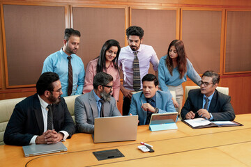 Indian professionals gathered around a senior colleague during a training session